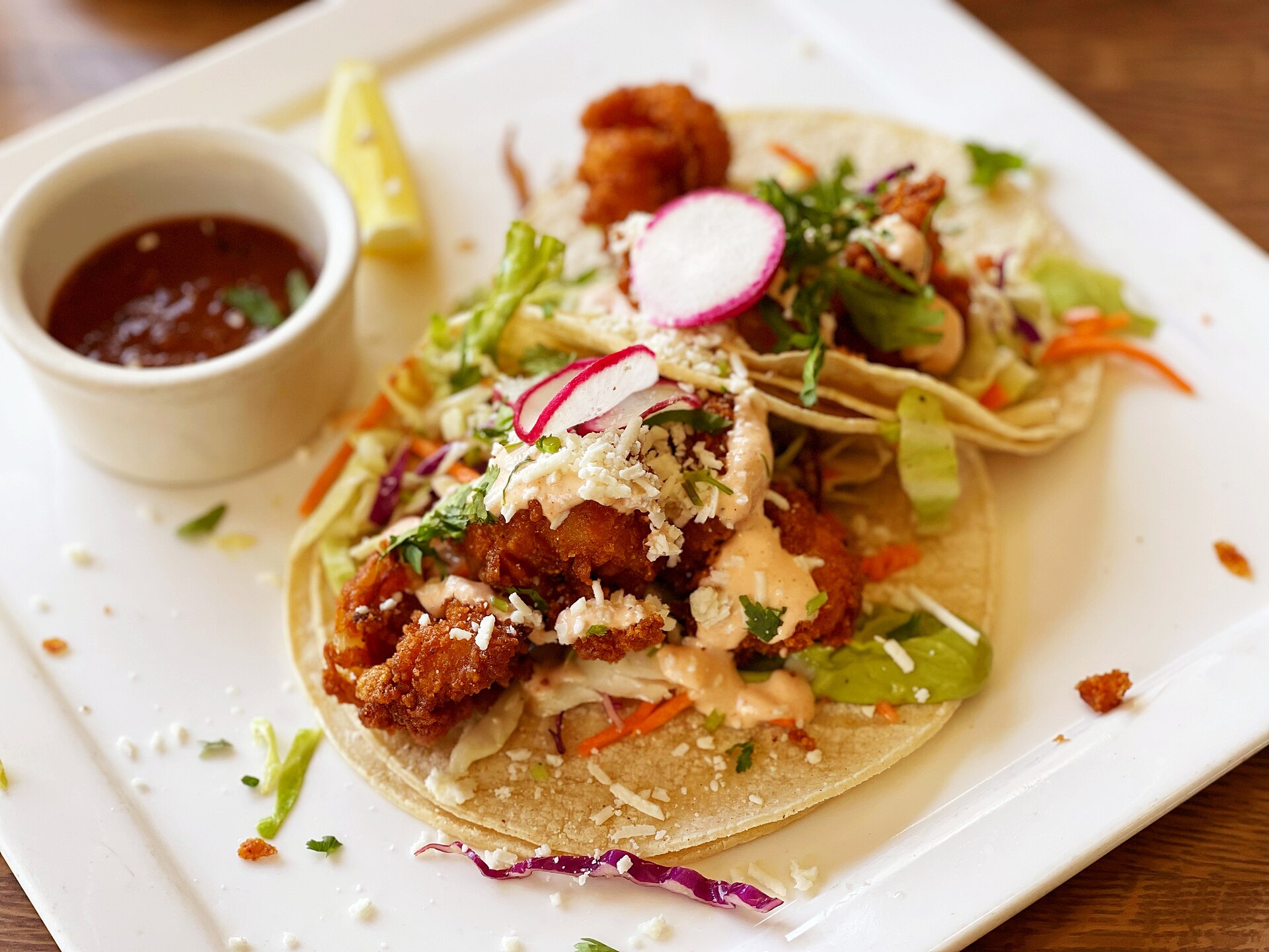A prepared serving of grilled shrimp tacos with cabbage slaw