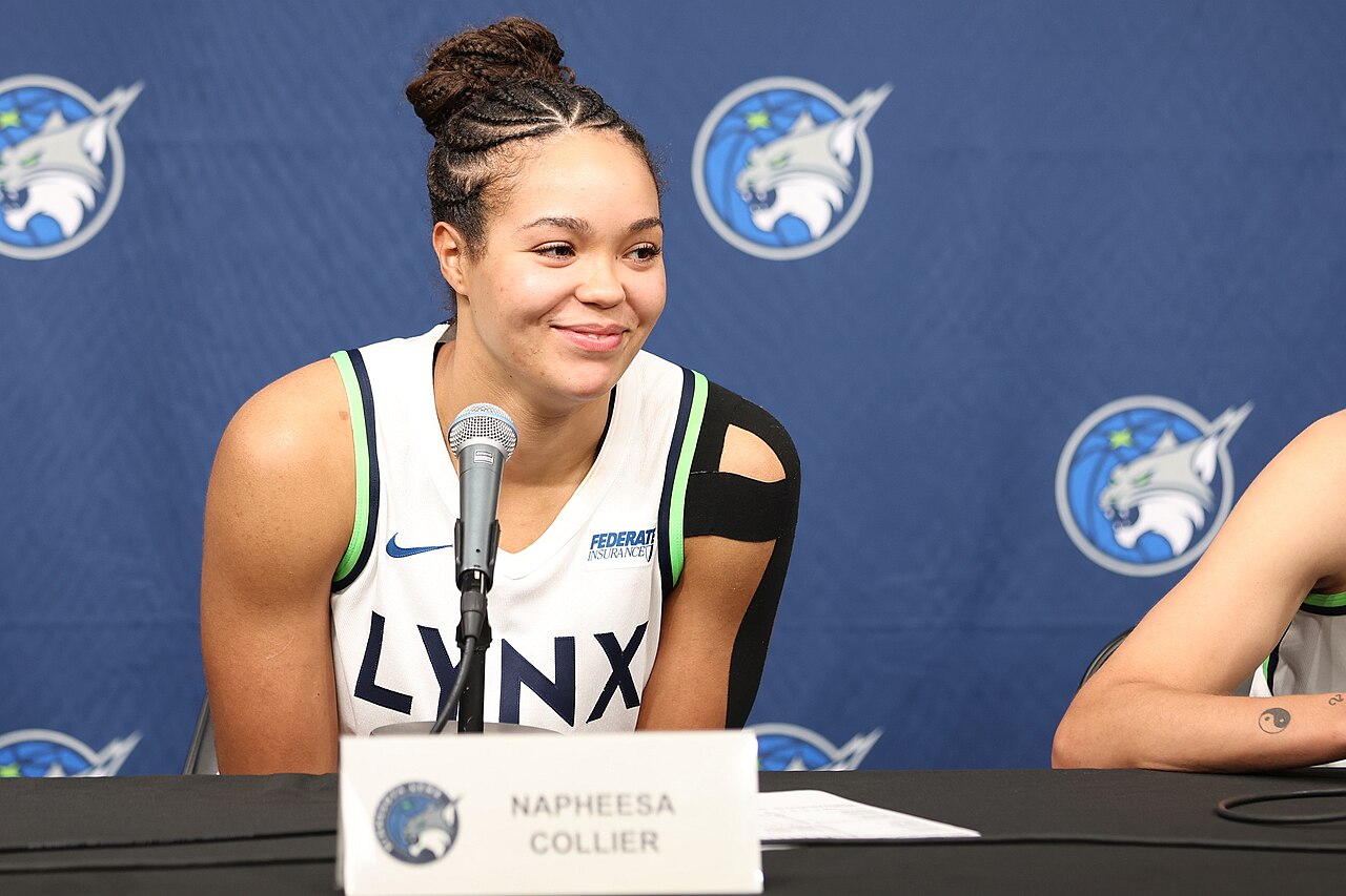 Napheesa Collier in a white Minnesota Lynx jersey smiling at a postgame news conference at Target Center in September 2025