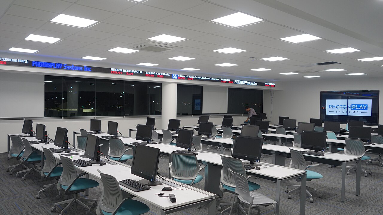 A digital stock ticker displays market prices and company symbols.