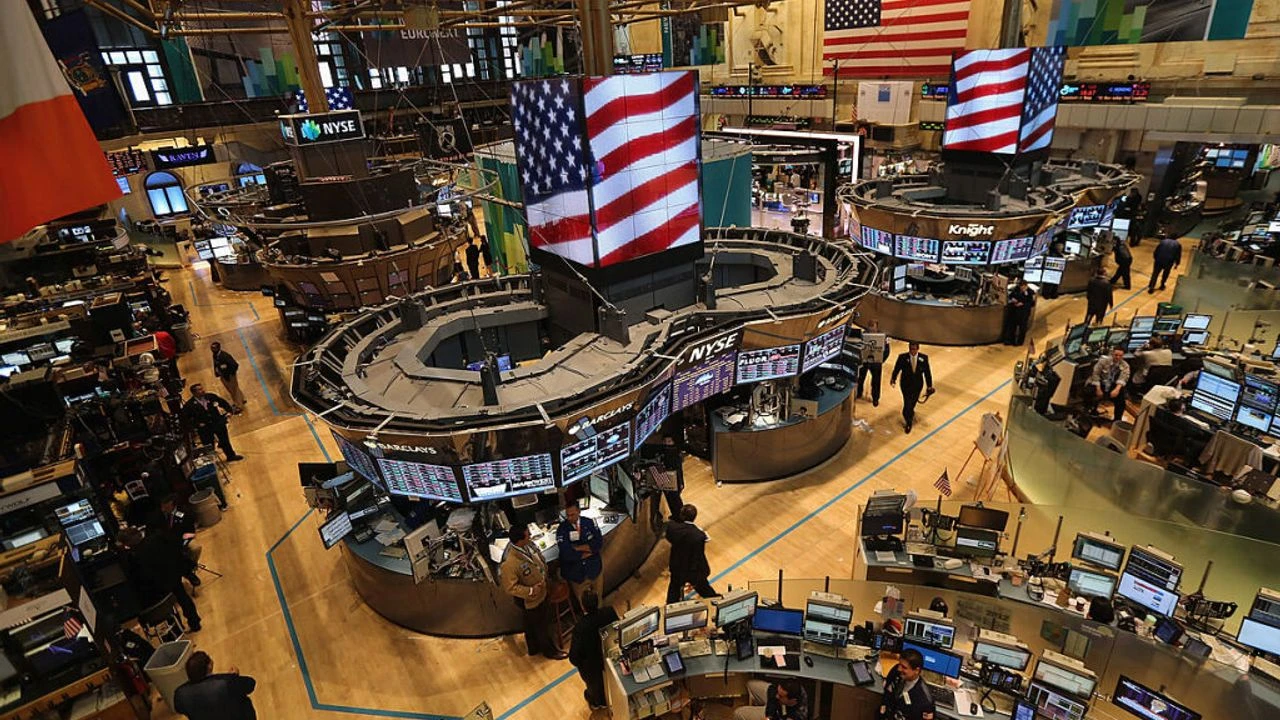 Traders work at posts on the New York Stock Exchange floor, with electronic market displays in the background; illustrative file photo, not Robinhood employees or the Oct. 27 earnings event.