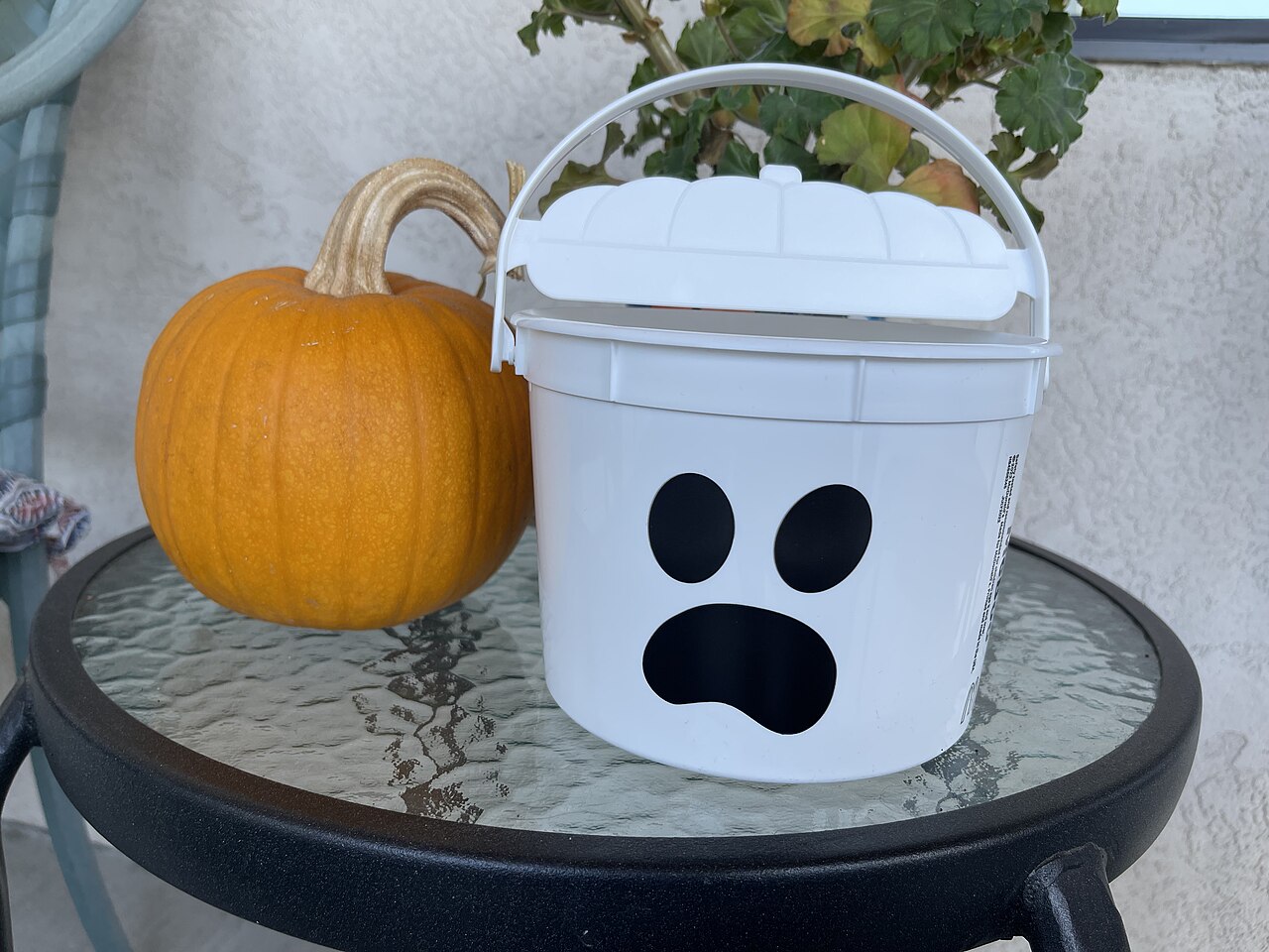 A white ghost-shaped McBoo Halloween pail from McDonald's 2022 Boo Bucket set beside a pumpkin