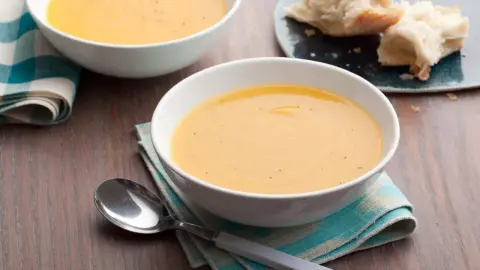 Creamy butternut squash soup served in a bowl with a contrasting garnish