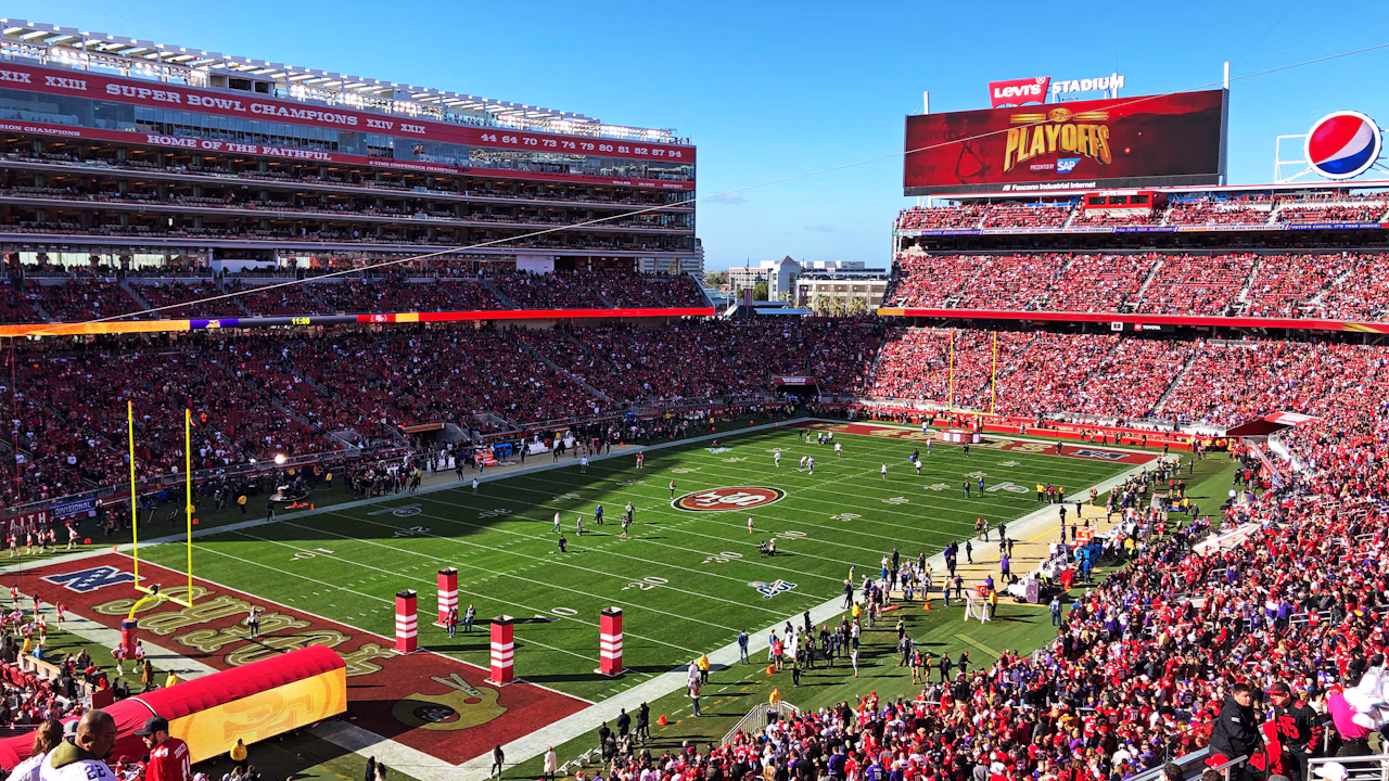 A packed professional football stadium during a daytime game