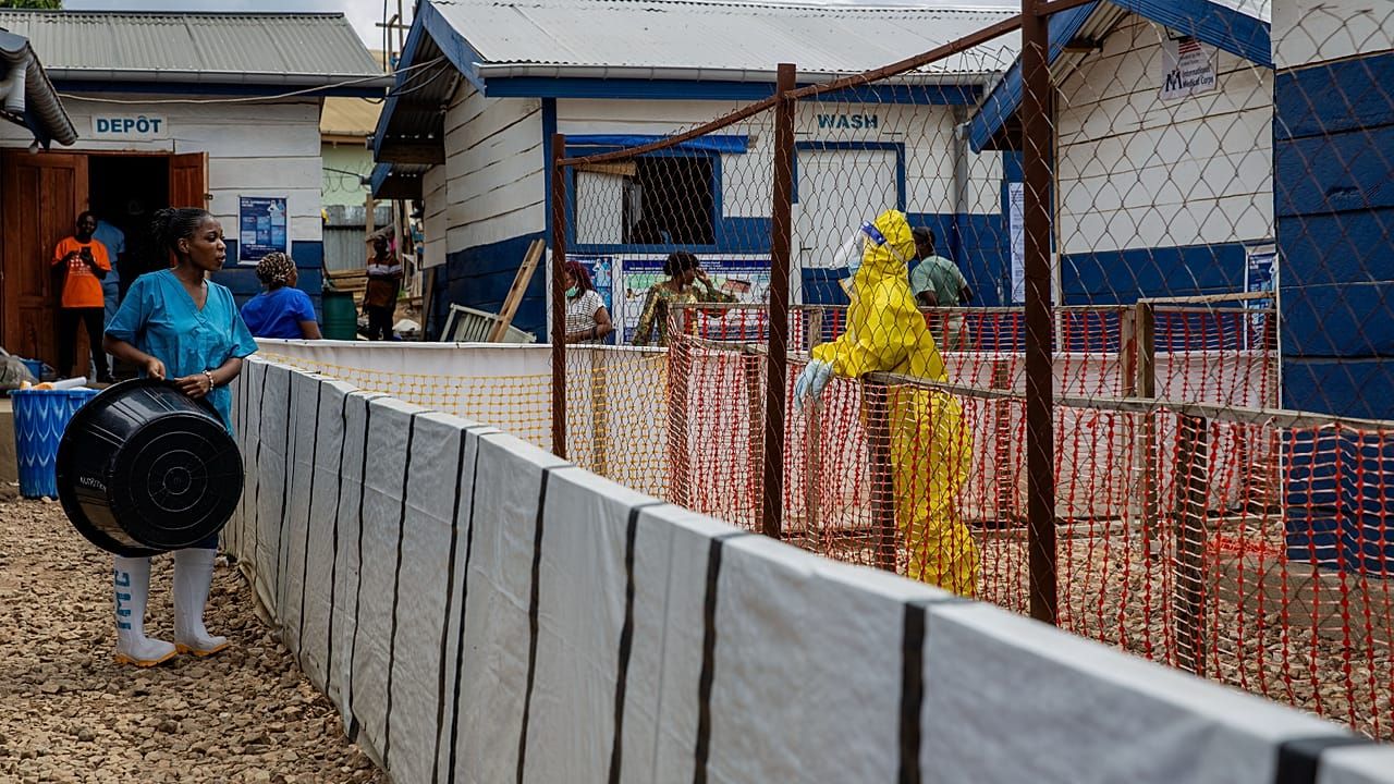 A healthcare worker speaks with a colleague at an Ebola treatment centre in Beni, Democratic Republic of the Congo; this is not a photograph of the patient in Nigeria.