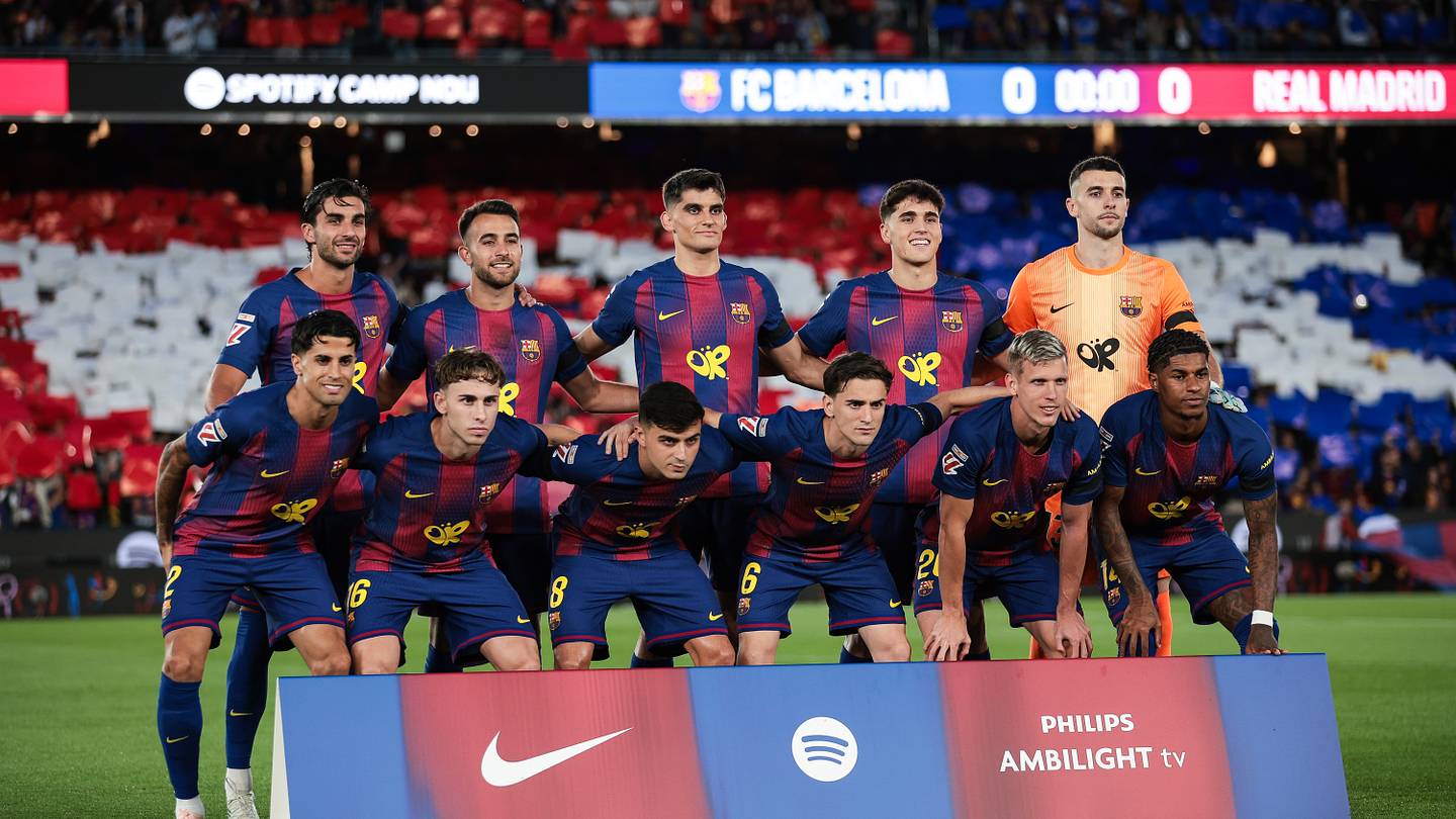 Barcelona players in red and blue line up at Spotify Camp Nou before an El Clásico against Real Madrid.