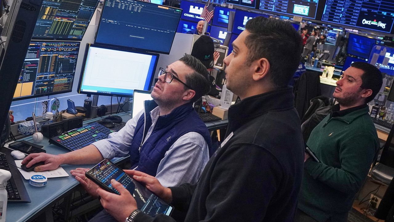 Traders monitor market screens on the New York Stock Exchange floor