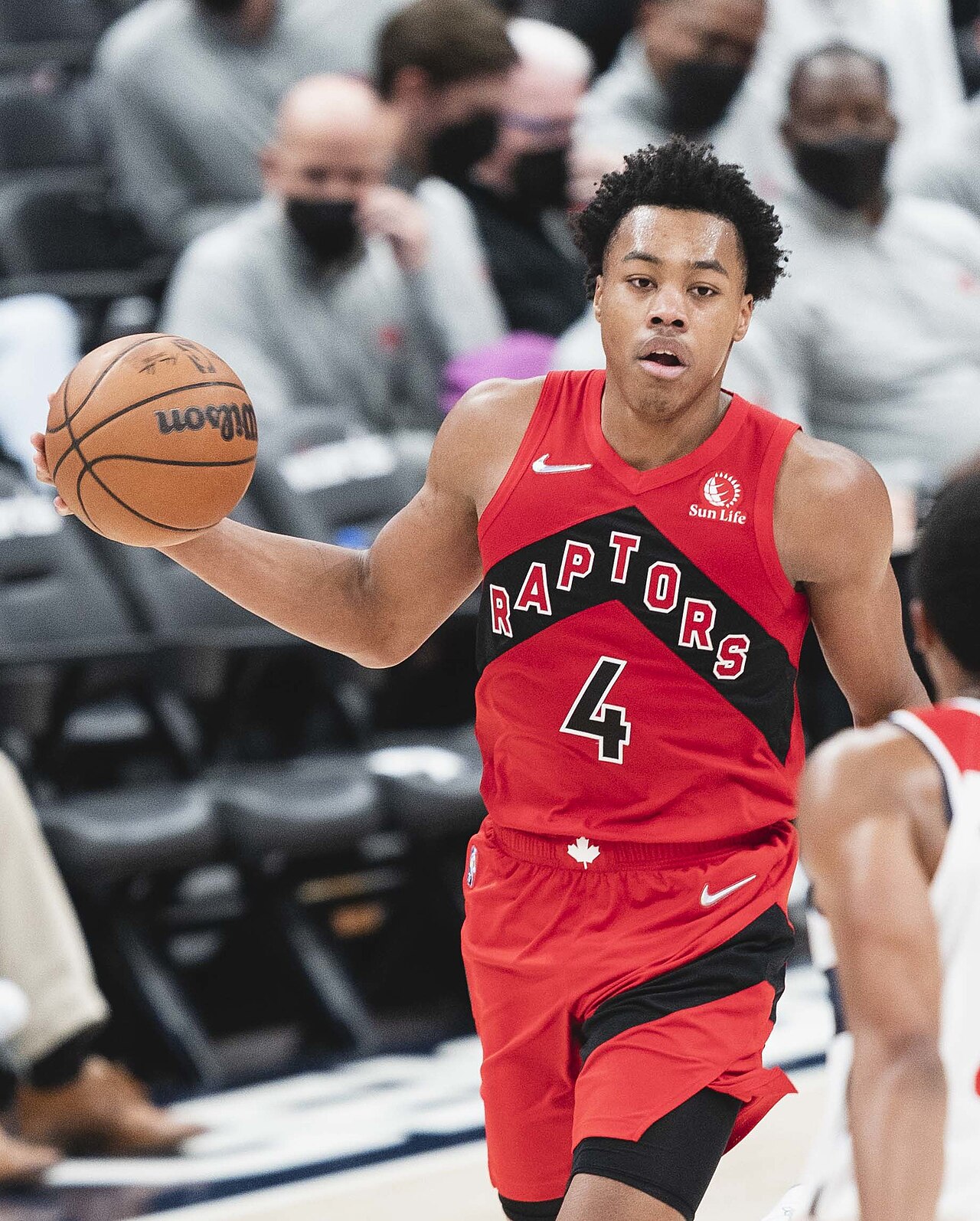 Toronto Raptors guard Scottie Barnes in a red number 4 jersey dribbling the ball up the court during a 2021 game against Washington