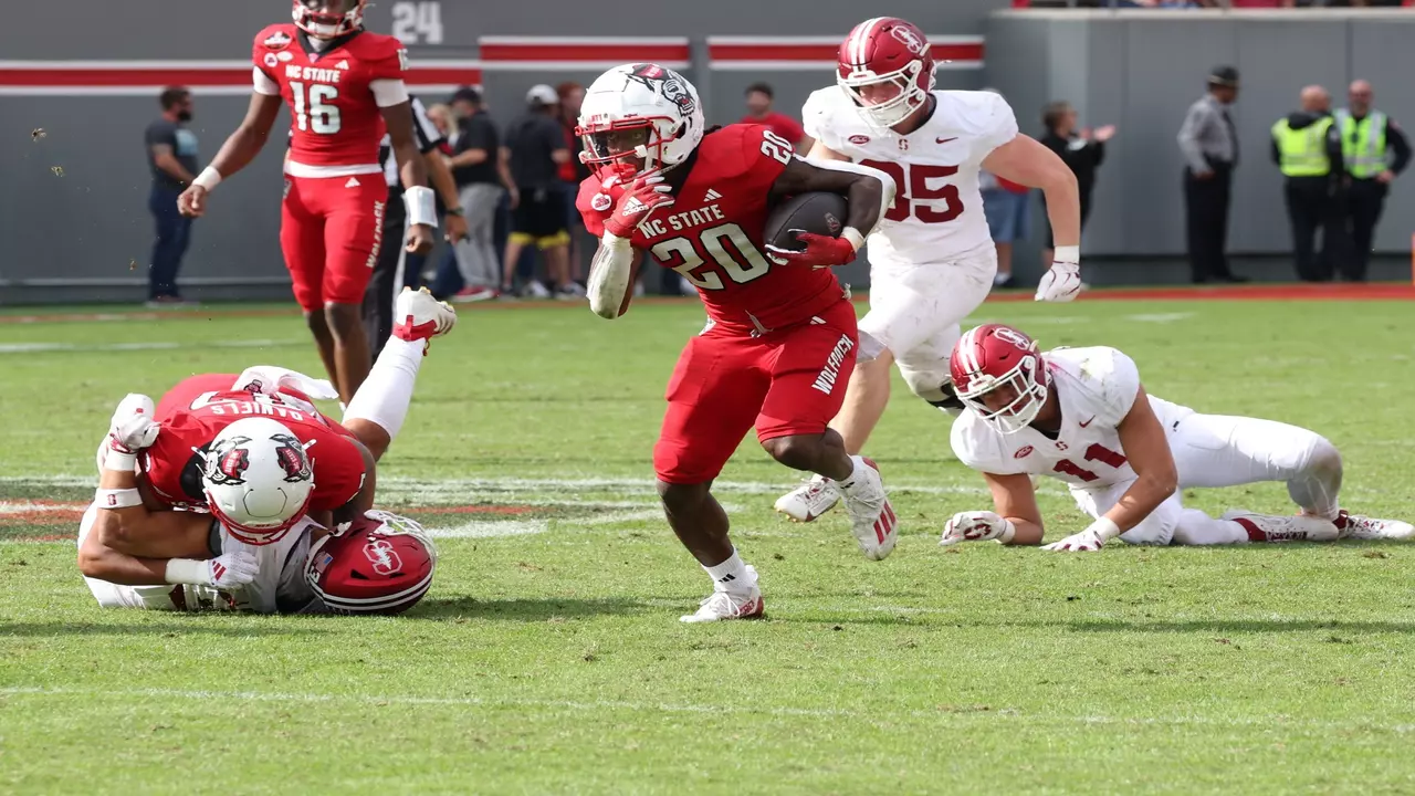 An NC State ball carrier runs through Stanford defenders during the teams’ 2024 meeting in Raleigh