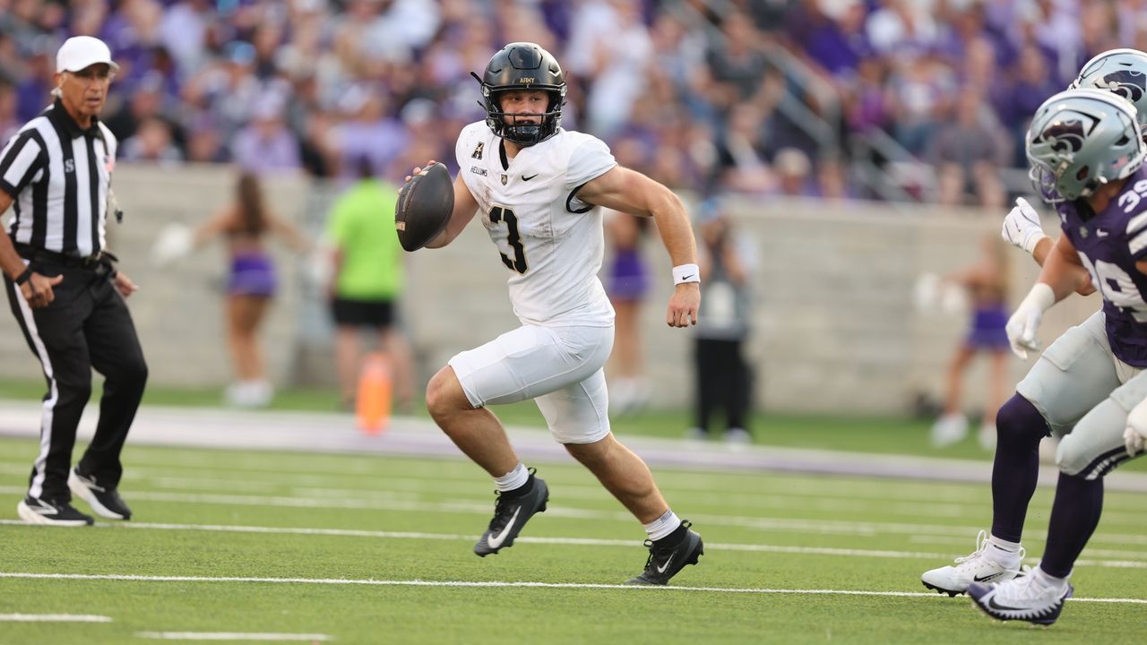 Army quarterback Cale Hellums runs with the ball during a college football game