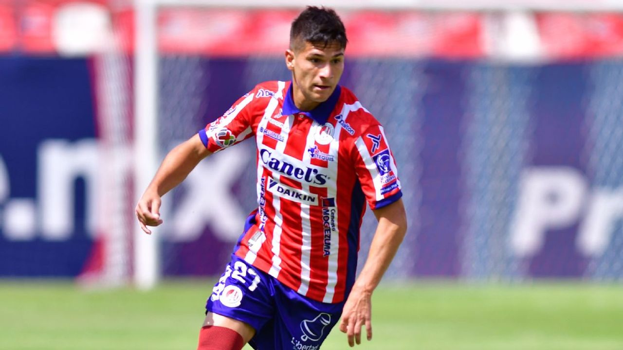 Benjamín Galdames carries the ball for Atlético de San Luis in the club’s red-and-white striped kit