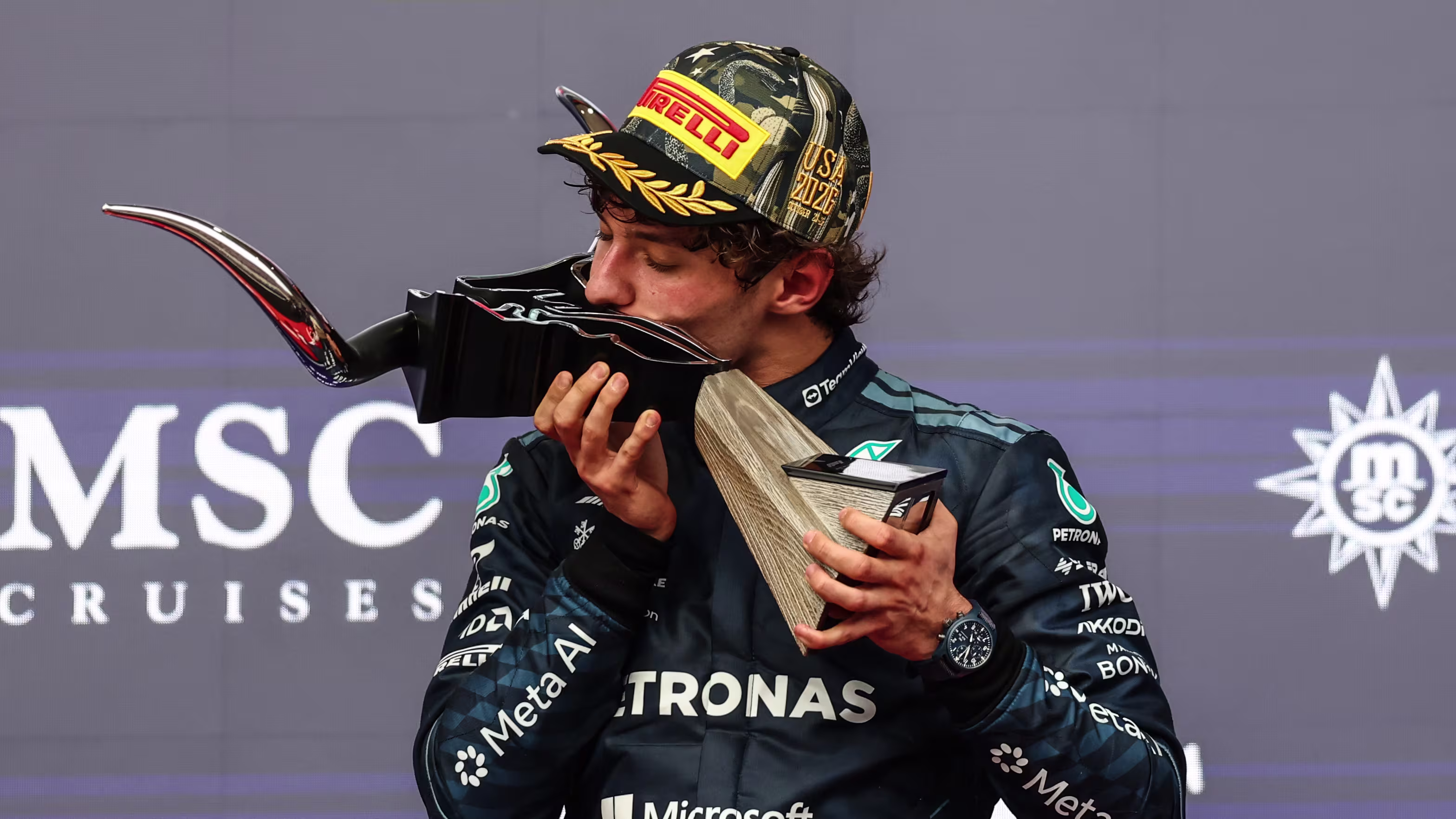 Kimi Antonelli kisses the winner's trophy after the 2026 United States Grand Prix in Austin, where Sophie Cunningham waved the finish flag