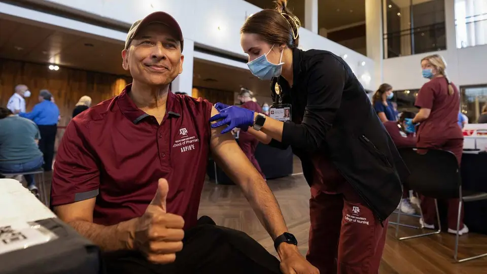 A nursing student administers a flu shot to a staff member at a Texas A&M University vaccination clinic.