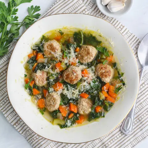 A prepared serving of italian wedding soup with turkey meatballs