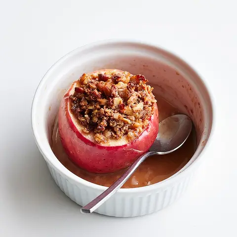 A prepared serving of baked apples with oats and walnuts