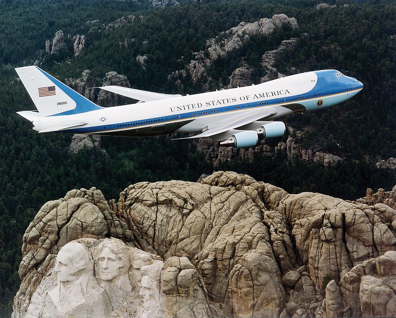 The presidential aircraft Air Force One, a blue and white Boeing 747, flying over the Mount Rushmore monument in South Dakota