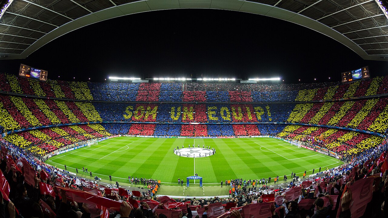 A packed Camp Nou during a night football match, viewed from the stands