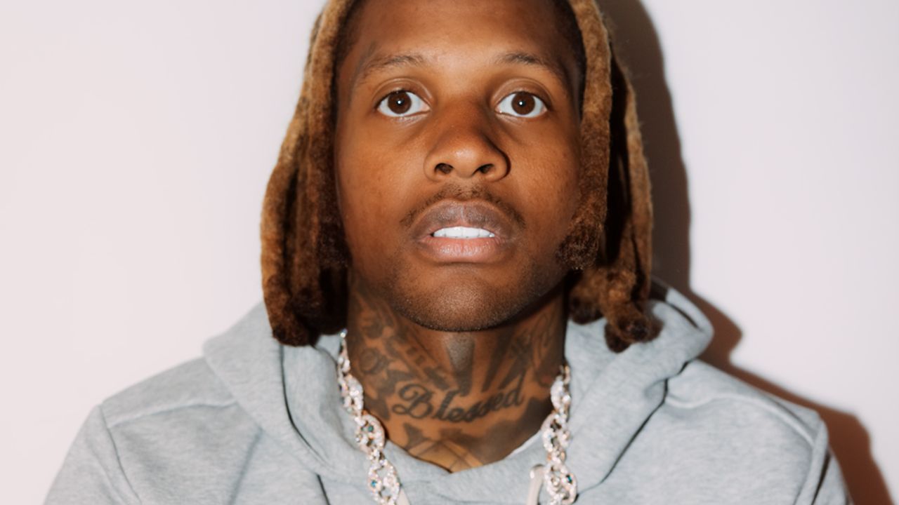 Rapper Lil Durk wears a gray hooded sweatshirt in a promotional portrait.
