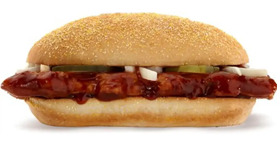 A McDonald’s McRib sandwich with barbecue sauce, onions and pickles on a soft bun.