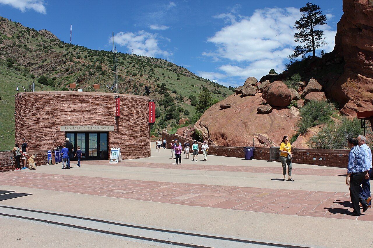 Tiered stone seating and stage of Red Rocks Amphitheatre set between towering red sandstone formations in Colorado