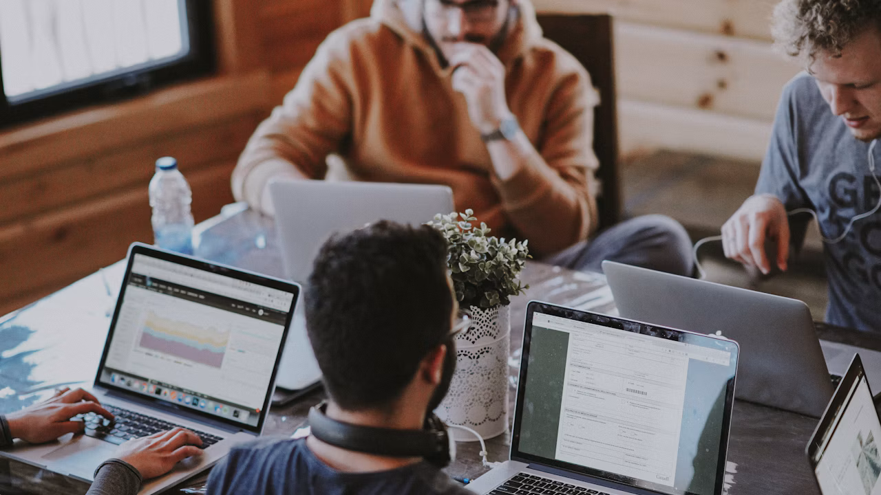 Illustrative photo of colleagues working together around a table; not a photo of Brian Chesky or Airbnb employees.