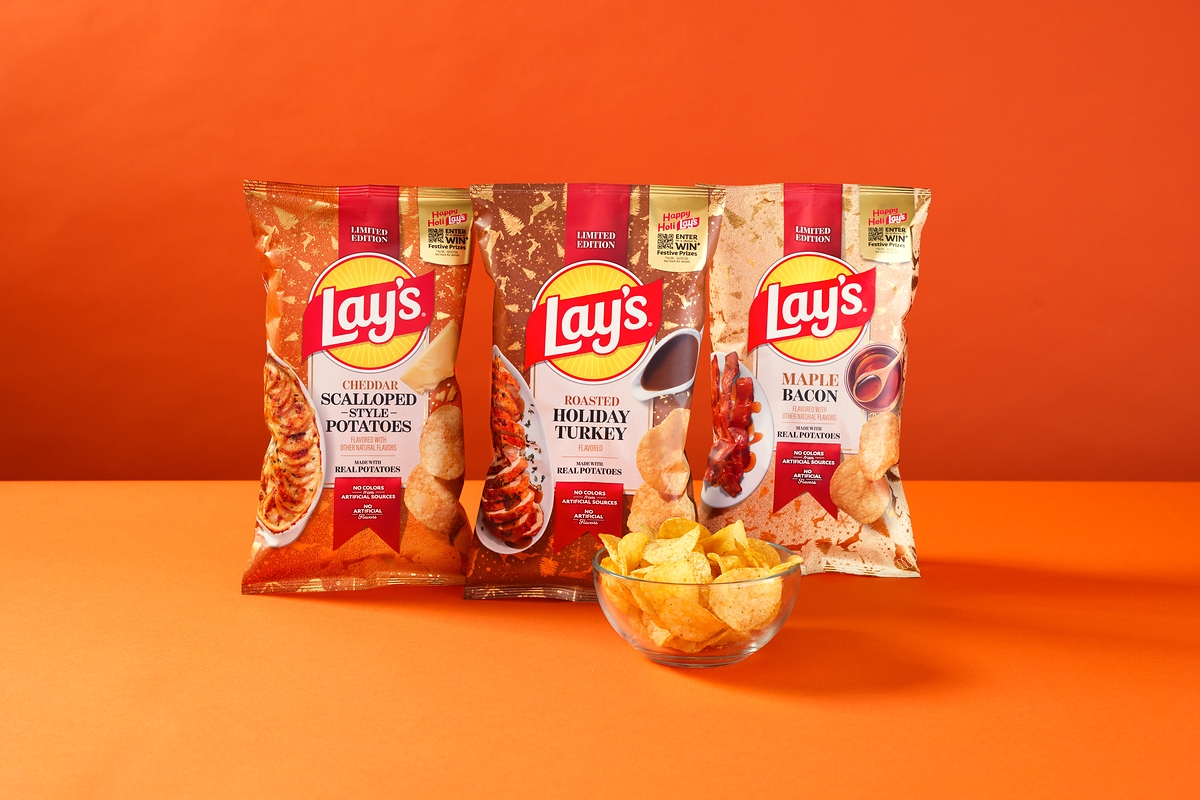 Bags of Lay's Cheddar Scalloped-Style Potatoes, Roasted Holiday Turkey and Maple Bacon chips in limited-edition holiday packaging, with a bowl of chips in front