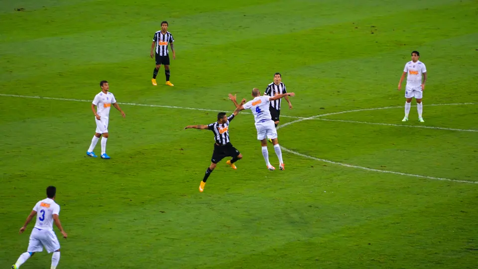 Players contest an aerial ball during a football match.