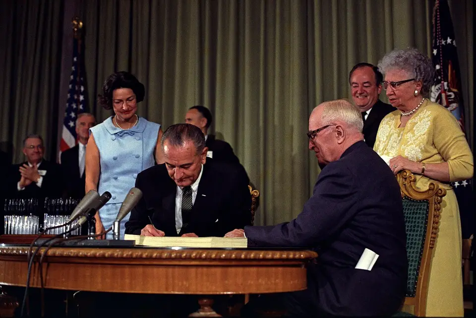 President Lyndon Johnson signing the Medicare bill in 1965 with former President Harry Truman seated beside him