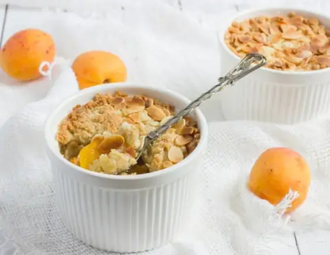 A prepared serving of apricot and almond fruit crisp