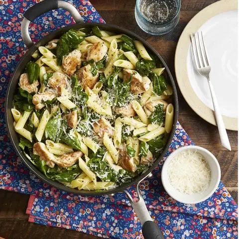 A prepared serving of chicken and spinach skillet pasta