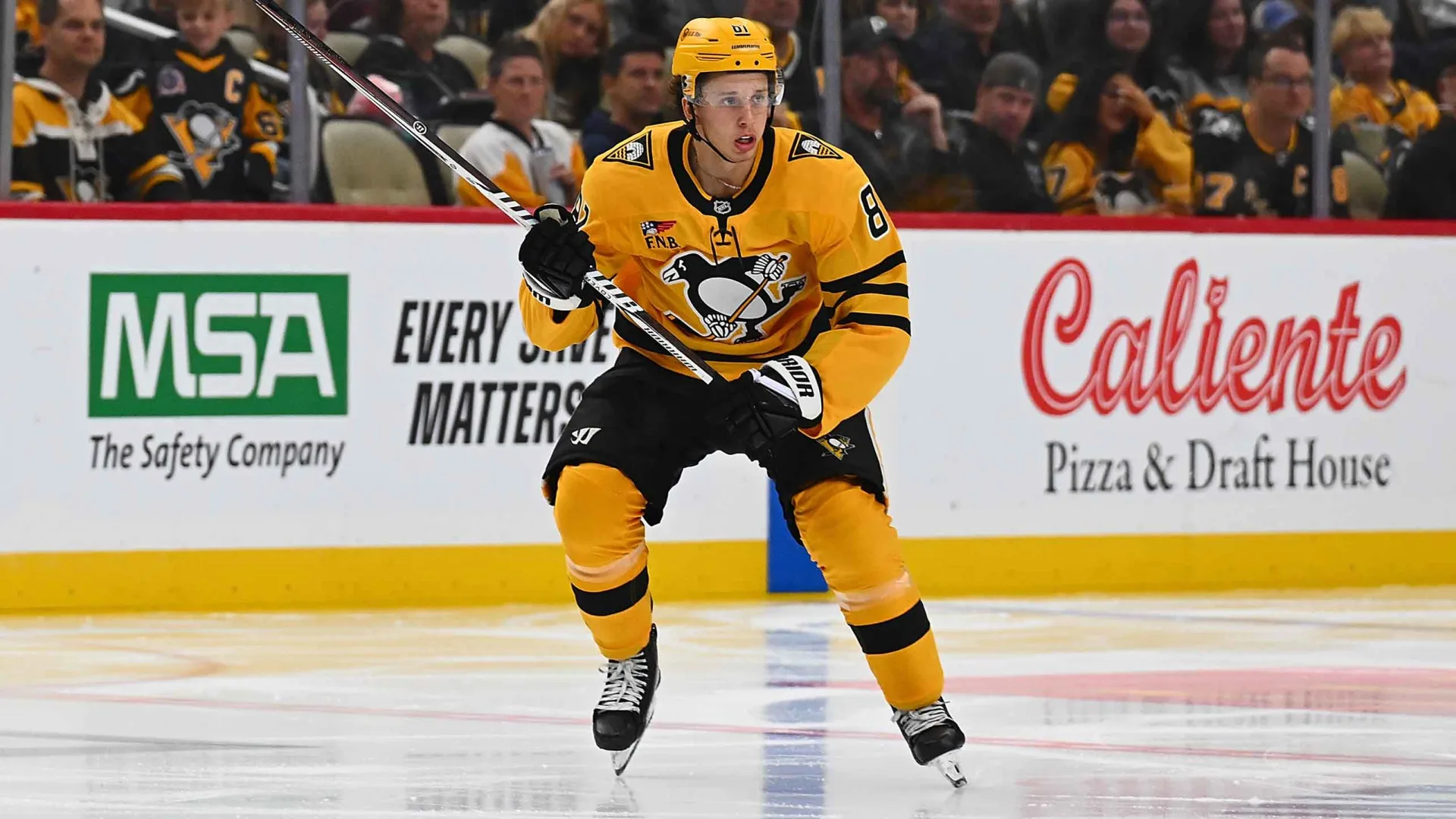 Pittsburgh Penguins forward Ben Kindel skating on the ice in his black and gold uniform.