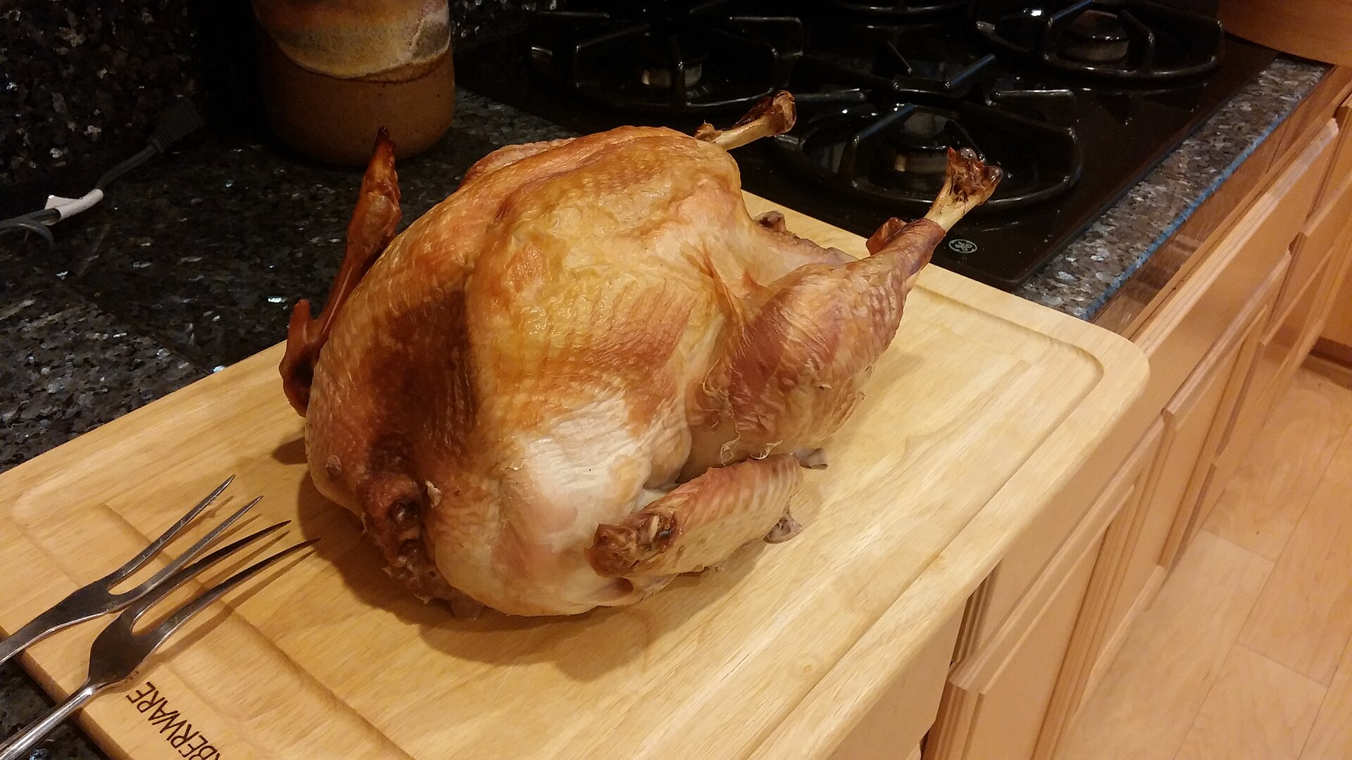 A roasted Thanksgiving turkey displayed on a platter as part of a holiday meal